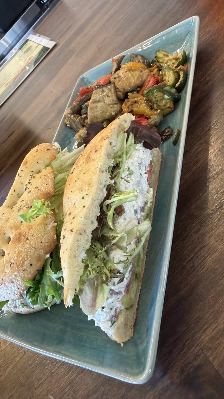 A fresh chicken salad focaccia sandwich with roasted vegetables on a platter, catering from Tino's Tazza in Kingston, NJ