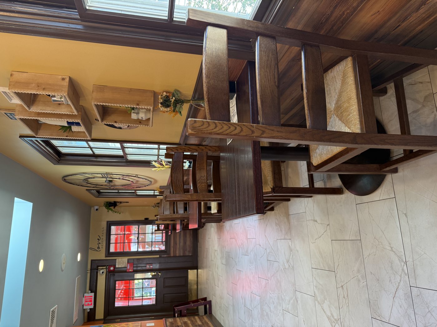 Sunny indoor seating with wooden tables and chairs at Tino's Tazza in Kingston, NJ