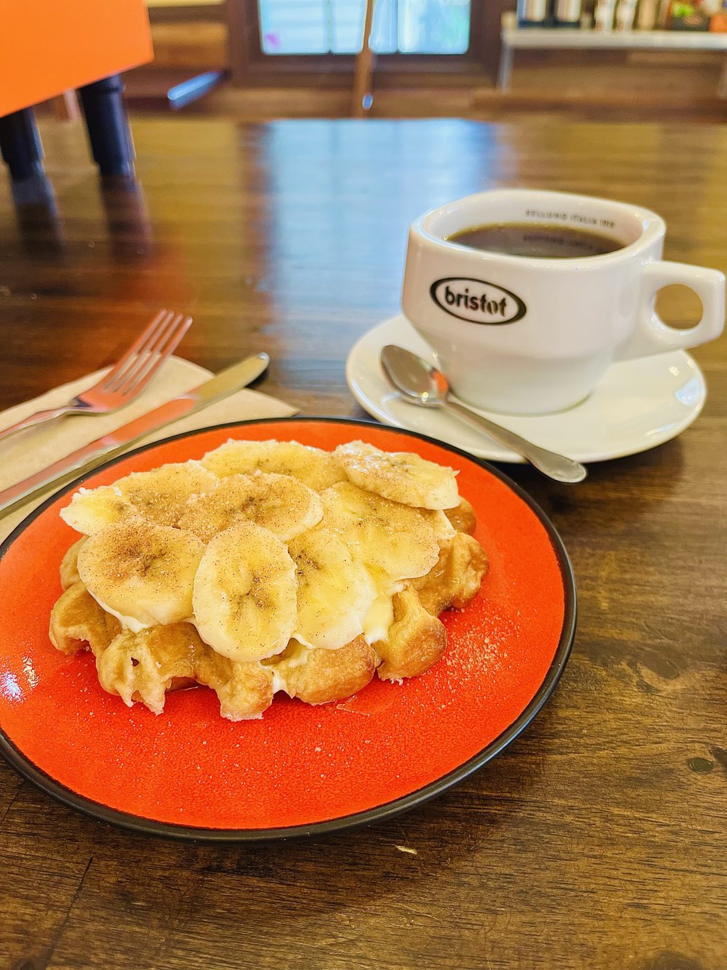 Belgian waffle topped with fresh banana, served with Bristot coffee at Tino's Tazza